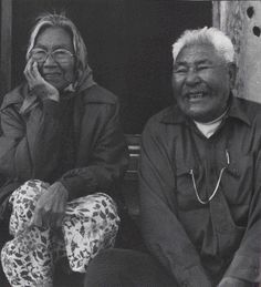 two people sitting next to each other smiling