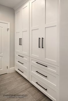 a large white closet with black handles and drawers on the doors is pictured in this image