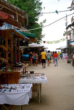 many people are walking through an outdoor market