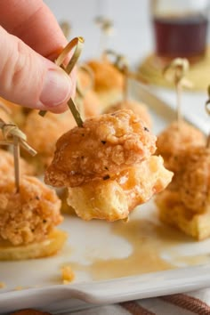 small appetizers with toothpicks in them on a white plate, ready to be eaten