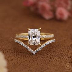 an engagement ring with a princess cut diamond in the center and side stones on each band