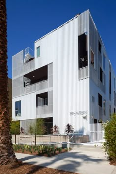 an apartment building with multiple balconies and palm trees