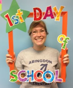 a woman holding up a sign that says 1st day of school