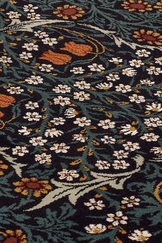 an intricately designed rug with flowers and leaves on the carpet is seen in this close up photo