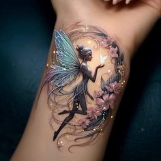 a woman's arm with a tattoo on it and a fairy sitting in the center