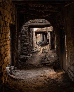 an old tunnel in the middle of a stone building with light coming from it's entrance