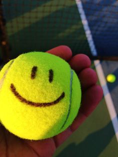 a tennis ball with a smiley face drawn on it