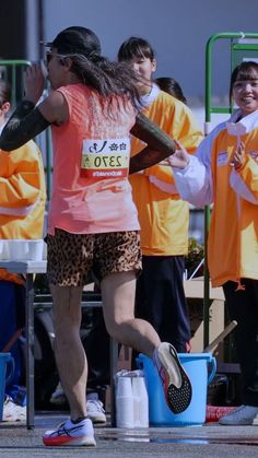 a woman running in a race with other people watching