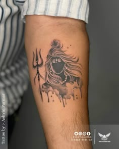 a man's arm with a tattoo on it and an image of a demon