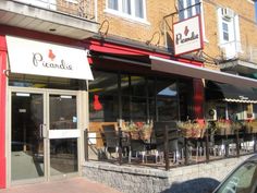 the outside of a restaurant with tables and chairs