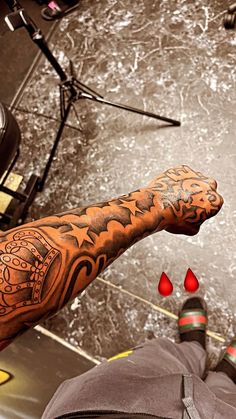 a man's arm with tattoos on it next to a microphone and some red drops