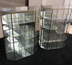 two large glass shelves with gold trimmings on the sides and black carpeting