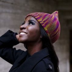 a woman wearing a colorful hat and black coat