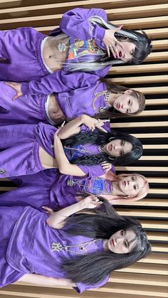 four girls in purple outfits standing next to each other