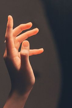 a person holding their hand up in the air with one hand extended to the other