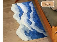 a blue and white rug sitting on top of a wooden floor next to a bed