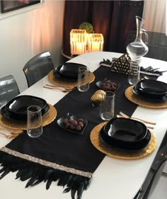 a table set with black and gold place settings