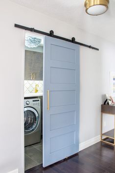 a blue door is opened to reveal a washer and dryer in the room