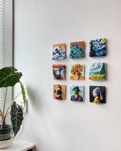 the wall is decorated with colorful paintings and a potted plant in front of it