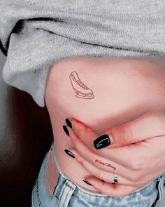 a woman's stomach with a shoe tattoo on her left side ribcage