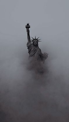 the statue of liberty is surrounded by fog