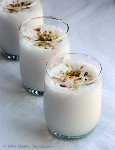 three glasses filled with food sitting on top of a white table covered in cloths