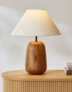 a wooden table with a lamp on top of it and a book next to it