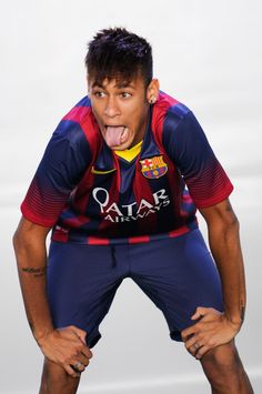 a man with his tongue out making a funny face while standing in front of a white background