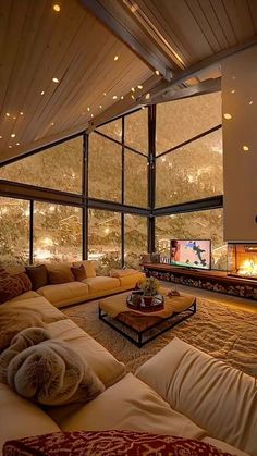 a living room with couches and a fire place in the corner, overlooking mountains