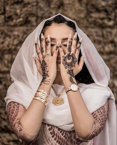 a woman covering her face with hands and tattoos