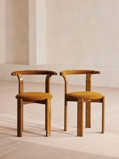 two wooden chairs sitting next to each other