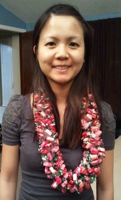 a woman standing in front of a mirror wearing a red and green beaded necklace