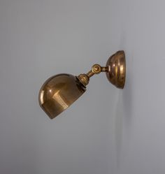 an antique brass wall light on a white wall