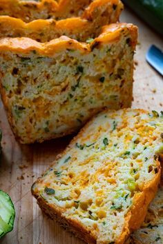 slices of zucchini bread sitting on top of a cutting board next to cucumbers