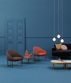 an image of a living room setting with blue walls and modern furniture on the floor