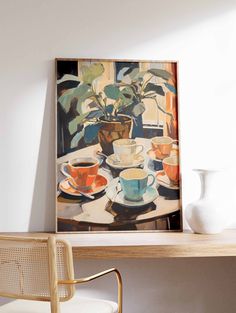 a painting on the wall above a table with cups and saucers