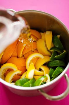 oranges, spinach and other vegetables are being mixed together in a saucepan