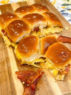 the ham and cheese sliders are cut in half on a cutting board with bacon