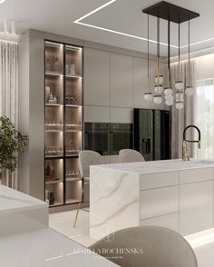 an elegant kitchen with marble counter tops and white cabinets, along with modern lighting fixtures