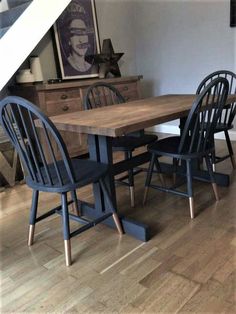 a dining room table and chairs with an open stair case in the background