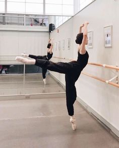 a ballerina is doing an acrobatic move in the middle of a dance studio