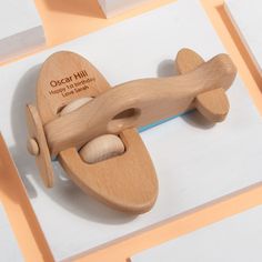 a wooden toy airplane on top of a white and orange background with the words oscar hill happy birthday