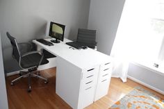 an office desk with a computer on top of it and a chair in front of it