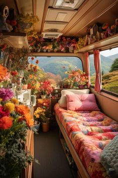 the interior of a camper with flowers and plants on the windows sills