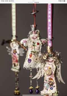 three ornaments are hanging from the ceiling in different colors and designs, one with angel's head on it