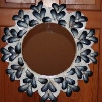 a white and black flower shaped mirror hanging on a door