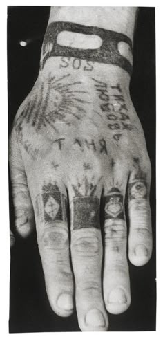 a person with tattoos on their hands and wrist is holding his hand up to the camera