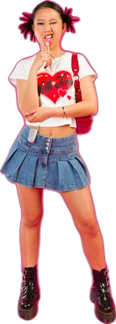 Girl standing in front of a pink backdrop licking a lollipop with her face scrunched up and one eye closed. She is wearing a white with jean top with a red heart on the front, pleated denim skirt, red vintage guess shoulder bag and black platform buckled doc martins. Girls Photoshoots, Paris Hilton Britney Spears, Pink Girly Aesthetic, Y2k Fashion Early 2000s, Y2k Inspo, Aesthetic Paris, Editorial Photoshoot, Early 2000s Fashion, Girly Aesthetic