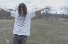 a person standing in a field with their arms outstretched