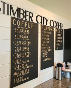 there are three signs on the wall that say timber city coffee and have different types of drinks